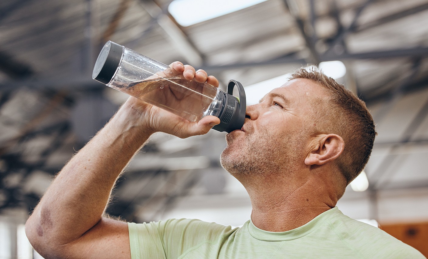 Mann trinkt Wasser aus Flasche