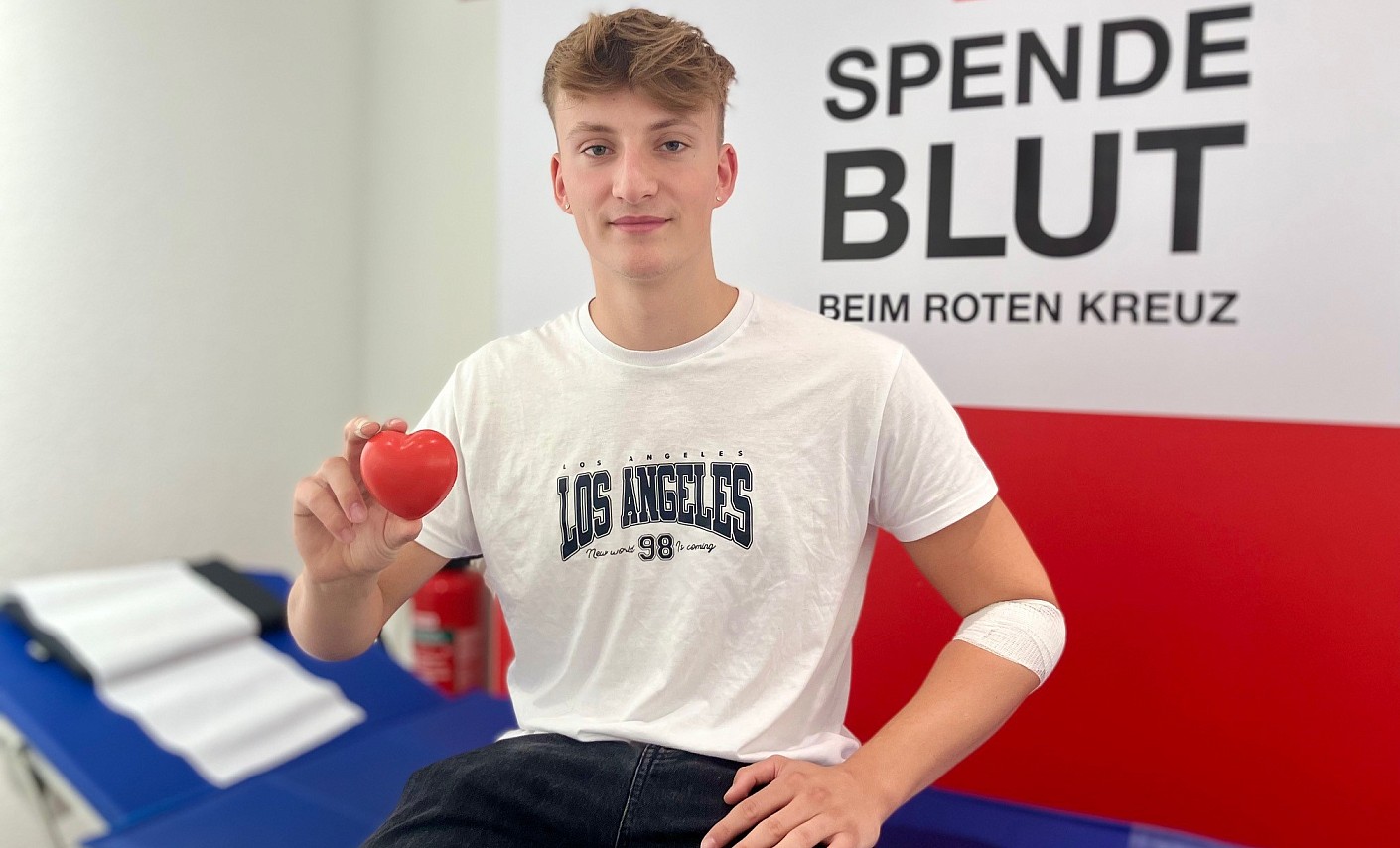 Junger Erstspender nach seiner Blutspende blutspender-mann-jung-sitzen-herz
